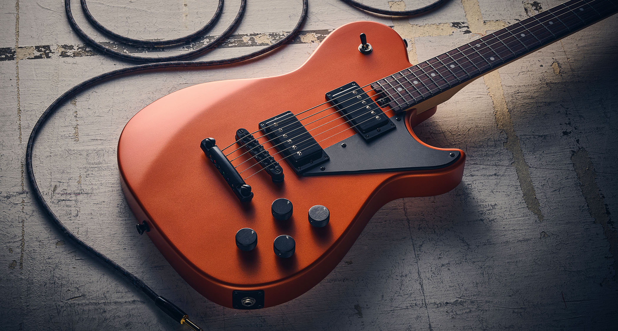 Manson MD-3 Mikey Demus Signature: the hot-orange T-style is photographed against a distressed grey-white background